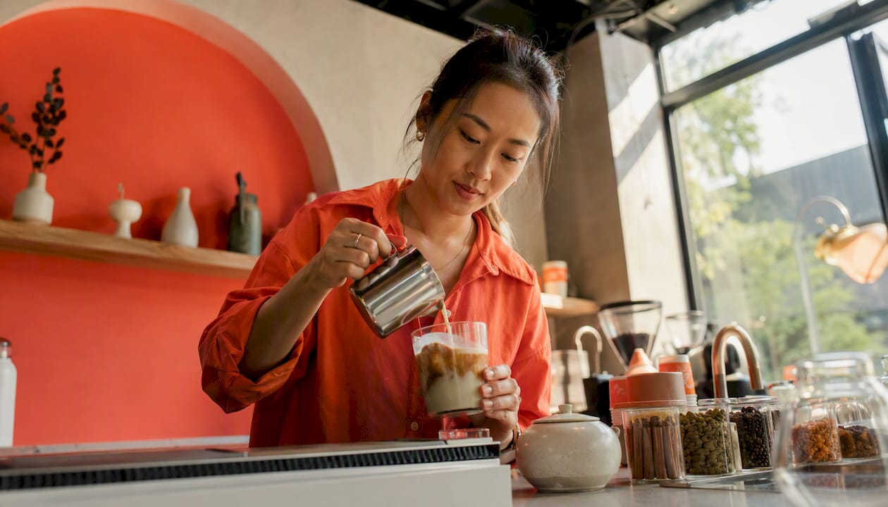 Woman preparing chai latte at home kitchen