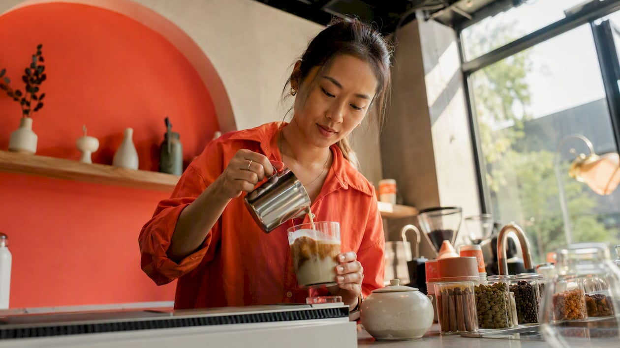 Woman preparing chai latte at home kitchen