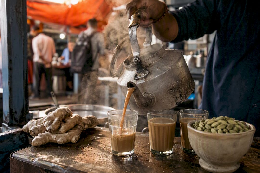 Chaiwala pouring kadak chai into glass cups